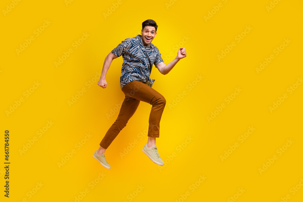 Full size photo of optimistic guy wear stylish shirt brown pants hurry run shoppping on black friday isolated on yellow color background