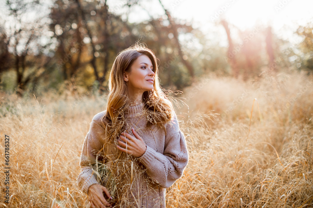 Beautiful portrait of a Caucasian girl in an autumn coat walks on a warm sunny day in the autumn park. Happy young woman enjoying golden autumn. autumn leaves Beautiful portrait of a Caucasian girl in an autumn coat walks on a warm sunny day in the autumn park. Happy young woman enjoying golden autumn. autumn leaves
