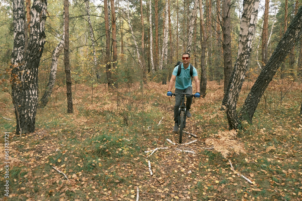 active lifestyle.A man with a backpack rides a mountain bike through the autumn forest.Mountain Bike active lifestyle.A man with a backpack rides a mountain bike through the autumn forest.Mountain Bike