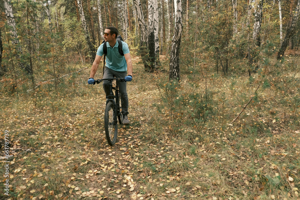 active lifestyle.A man with a backpack rides a mountain bike through the autumn forest.Mountain Bike