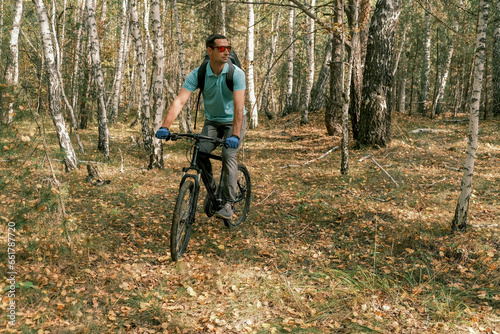 active lifestyle.A man with a backpack rides a mountain bike through the autumn forest.Mountain Bike