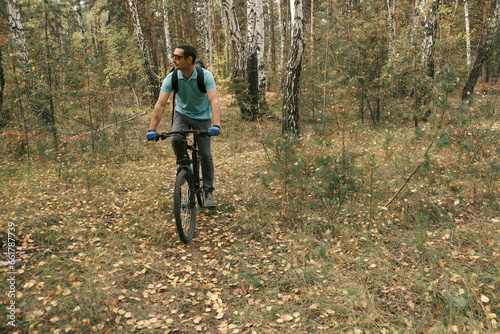 active lifestyle.A man with a backpack rides a mountain bike through the autumn forest.Mountain Bike © anwel
