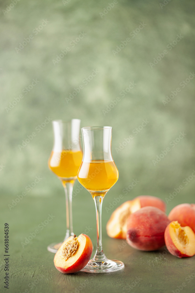 Peach liqueur in grappas glasses and fresh peaches on the table. Copy space Peach liqueur in grappas glasses and fresh peaches on the table. Copy space