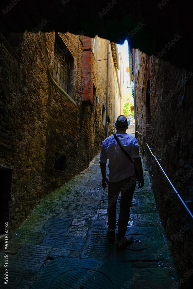 Tourist walking in a small alley in Montepulciano, Tuscany, Italy
