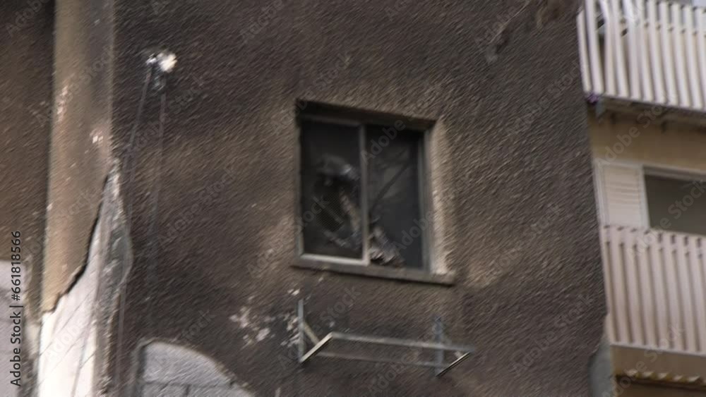 A handheld camera clip of a shattered house front, with a camera movement towards a broken window during the Hamas attack on Israel on October 2023.