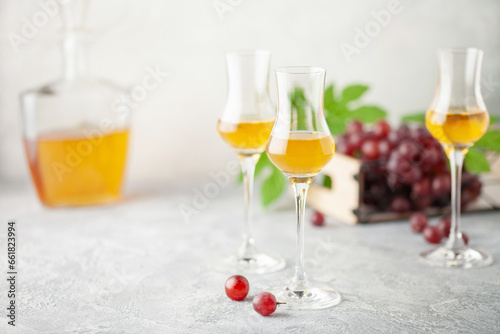 Grape vodka. Strong alcoholic drink in glasses on the table. Fresh grapes