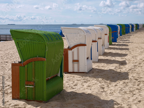 Line of Strandkorb: Traditional European Beach Chairs on Sandy Shore