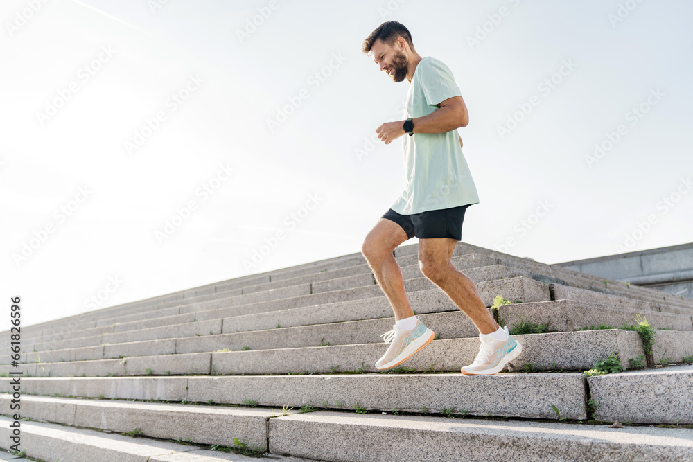 Fitness training in sportswear T-shirt and shorts.  Motivation photography for an active and healthy lifestyle.  The man is a professional running instructor.