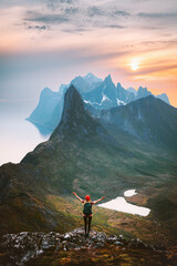 Norway travel outdoor activity traveler raised arms alone hiking in mountains summer vacations healthy lifestyle success motivation concept explore Senja island