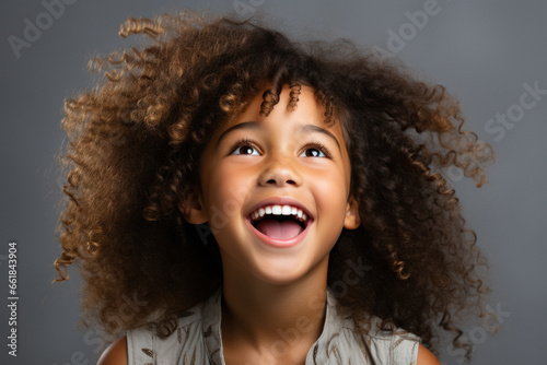 Happy multinational little preschool girl in casual clothes on grey background