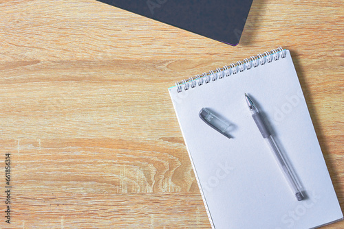 an open notepad for notes a fountain pen and a laptop on a wooden table with a copy space top view