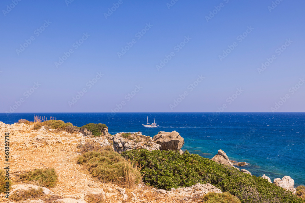 View from mountain of blue water of Mediterranean sea to passing sailing yacht. Rhodes. Greece.