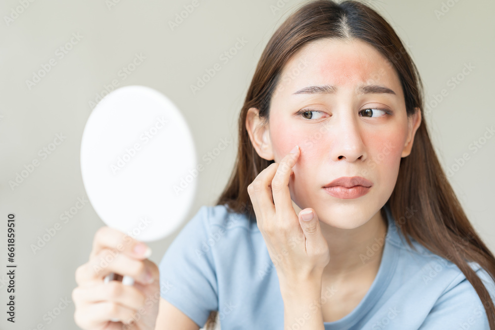 Dermatology, scratch asian young woman looking at mirror, expression worry and itch, itchy allergy or allergic sensitive reaction, red spot or rash on her face. Beauty care from skin problem treatment Dermatology, scratch asian young woman looking at mirror, expression worry and itch, itchy allergy or allergic sensitive reaction, red spot or rash on her face. Beauty care from skin problem treatment