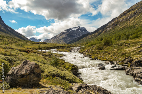 Wild river in the Jotunheimen National Park in Norway with mountain Styggehoe in the background - way to the Spiterstulen settlement photo