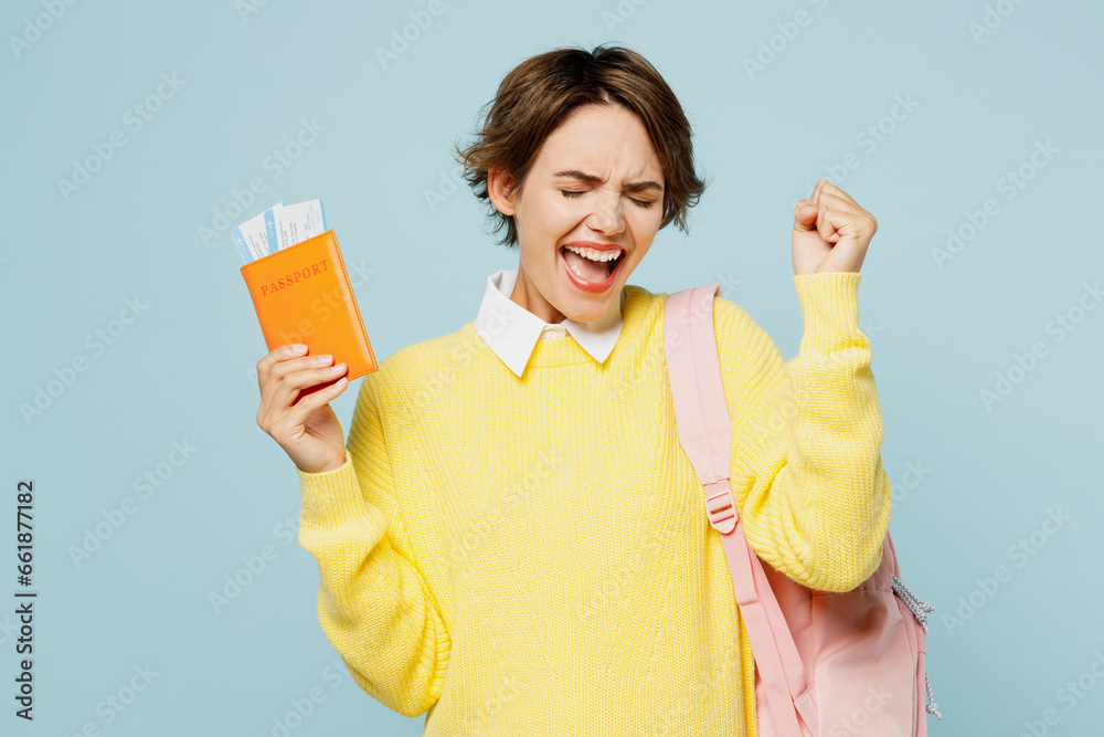Traveler student woman wears casual clothes hold passport ticket isolated on plain blue background Tourist travel abroad in free time rest getaway. Air flight trip journey, university college concept Traveler student woman wears casual clothes hold passport ticket isolated on plain blue background Tourist travel abroad in free time rest getaway. Air flight trip journey, university college concept