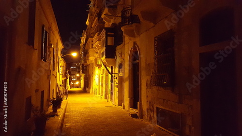 A dimly lit narrow street at night