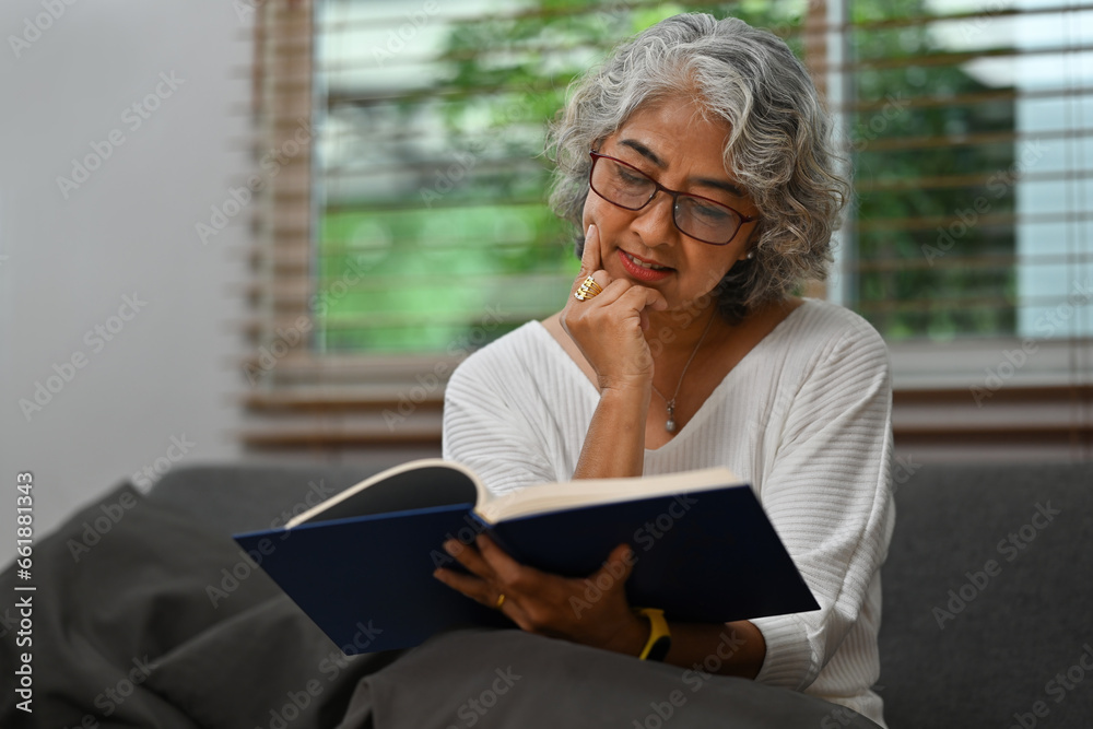 Satisfied Senior Asian woman reading book, favorite literature, happy middle-aged female relaxing, enjoying free time, the weekend at home Satisfied Senior Asian woman reading book, favorite literature, happy middle-aged female relaxing, enjoying free time, the weekend at home