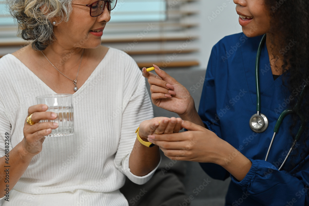 Φωτογραφία Cropped shot image of An African-Asian nurse or caregiver giving medicine to a s