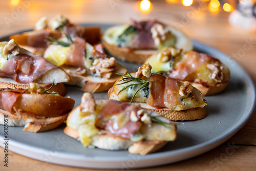 Christmas canapes made of pears, blue cheese and parma ham