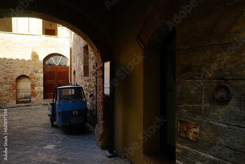 Old car in a desolated builiding of a Tuscany village, Italy photo