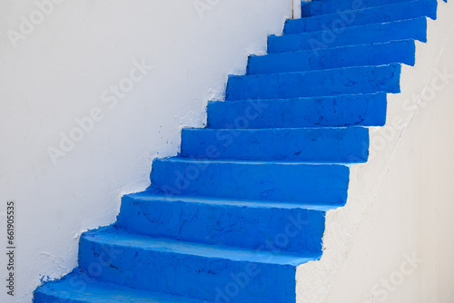 Fototapeta Naklejka Na Ścianę i Meble -  Greek blue stairs against the background of the white facade of the house. Kos island. Greece