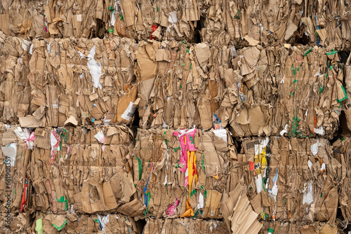 bundled stacks of old waste paper collected for recycling in front of a recycling plant