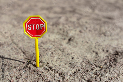 Toy STOP sign on the sand. STOP road sign in a children's sandbox
