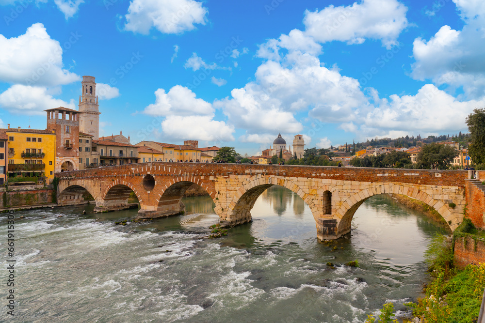 Verona, Italy - January 21 2023 - Tourists crossing the river ADige over the Ponte Pietra (Pietra bridge)