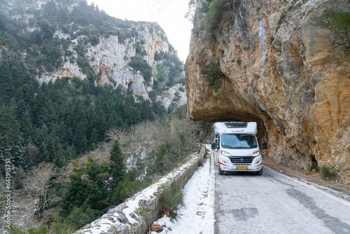 Langada, Greece - 9 February 2023 - Campervan on the Langada-Taygetos Pass on snowy road in the mountains of Greece photo