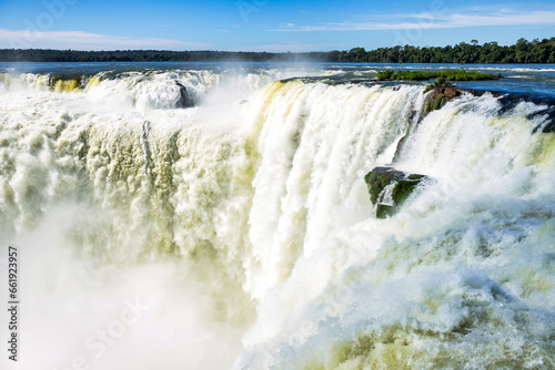 Close up of Devil's Mouth of Iguazu (Iguacu) waterfalls in Argentina, amazing sunny waterfall landscape. View of majestic powerful water cascade, sunshine day. World nature concept. Copy ad text space