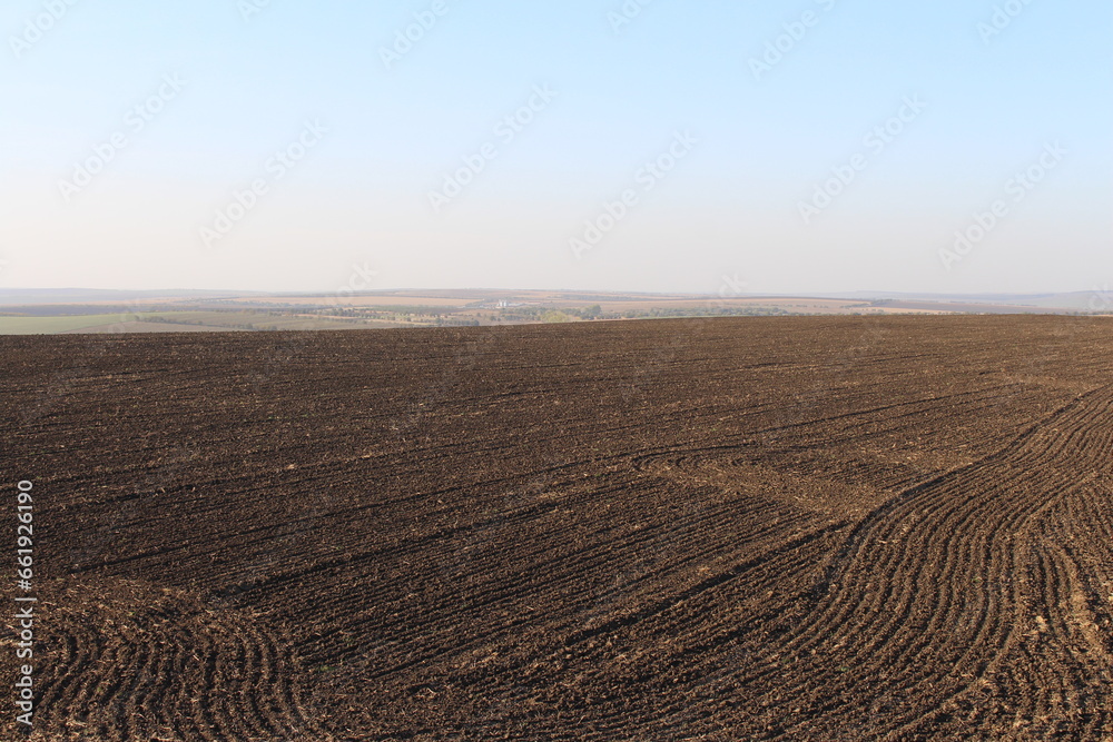 A large brown field with a blue sky