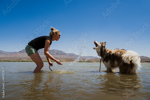 A woman splashes in the water with her dog at Caballo Lake State Park, New Mexico photo