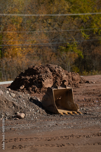 Excavator bucket next to dirt pile