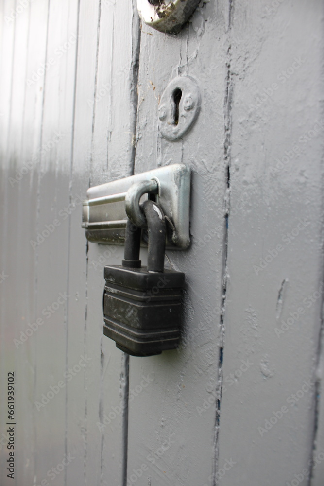 A locked outdoor shed with a padlock and keyhole A locked outdoor shed with a padlock and keyhole