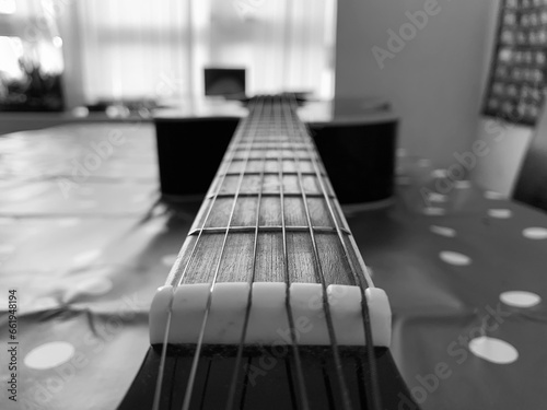A 6 String acoustic guitar close up focus on top of fret board photo