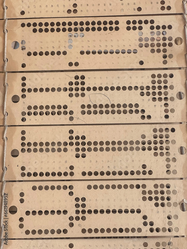 Close up view of punched cards on old working jacquard industrial weaving loom.