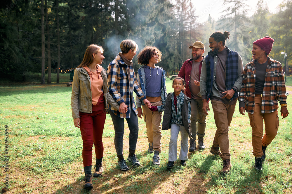 Cheerful multiracial families enjoying in walk in nature during autumn.