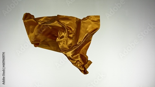 Smooth Elegant Golden Satin Cloth Separated on White Background. Texture of flying fabric.
