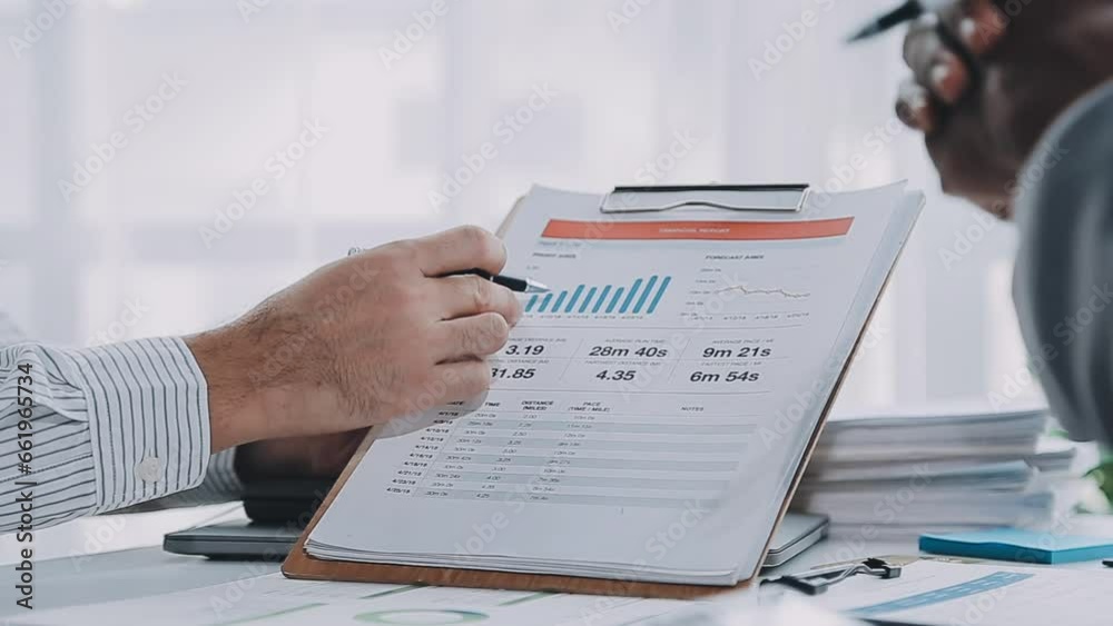 Group of confident business people point to graphs and charts to analyze market data, balance sheet, account, net profit to plan new sales strategies to increase production capacity. Group of confident business people point to graphs and charts to analyze market data, balance sheet, account, net profit to plan new sales strategies to increase production capacity.