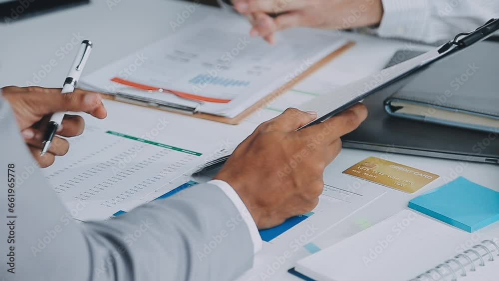 Group of confident business people point to graphs and charts to analyze market data, balance sheet, account, net profit to plan new sales strategies to increase production capacity. Group of confident business people point to graphs and charts to analyze market data, balance sheet, account, net profit to plan new sales strategies to increase production capacity.