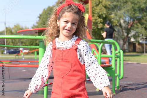 Little girl is playing on the children's playground with hulahop photo