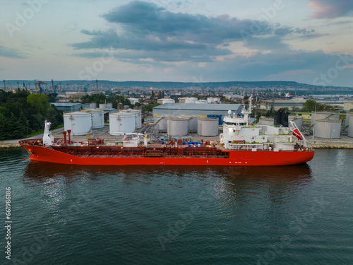 Tanker ship refueling at an oil terminal with storage silo's in