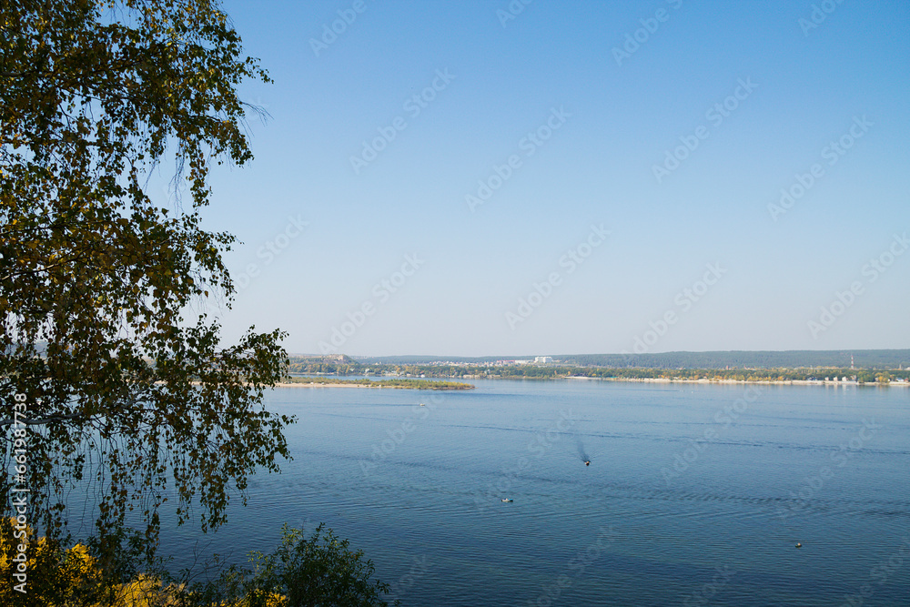 trees on the lake. Autumn landscape. View of the blue river from the shore 