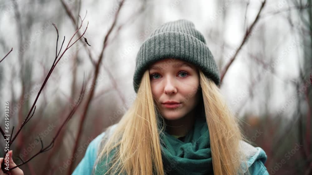 Beautiful girl in forest. Portrait of young woman on nature outdoors in warm hat in autumn. Cute and shy female looks down in embarrassment and smiles. Walking at leisure, rest and relax in solitude. Beautiful girl in forest. Portrait of young woman on nature outdoors in warm hat in autumn. Cute and shy female looks down in embarrassment and smiles. Walking at leisure, rest and relax in solitude.