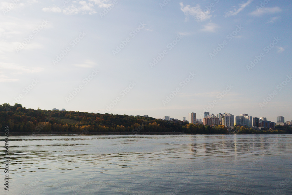 Fototapeta premium view of the city and river. landscape of a big river with steep banks. clouds over the blue river. dawn over the lake