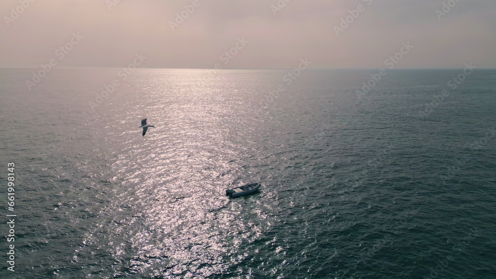 Aerial view yacht sailing. Boat floating on calm ripple ocean surface at summer Aerial view yacht sailing. Boat floating on calm ripple ocean surface at summer
