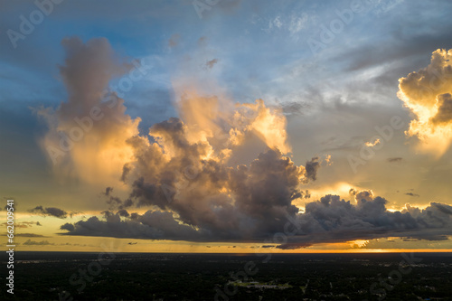 Colofrul clouds brightly illuninated by setting sun on evening sky. Changing cloudscape weather at sunset photo