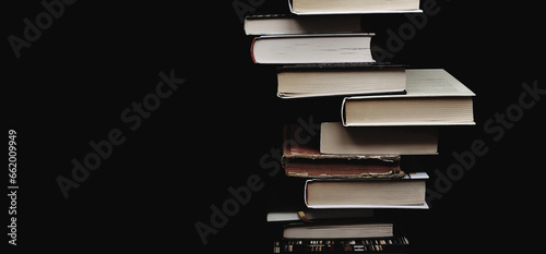 Composition of piled up books on a black background. Minimal corner composition. Copy space. Educational concept