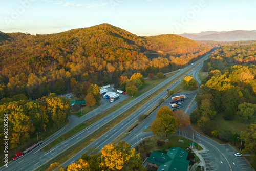 Top view of large rest area near busy multilane american freeway with fast moving cars and trucks. Recreational resting place during interstate traveling