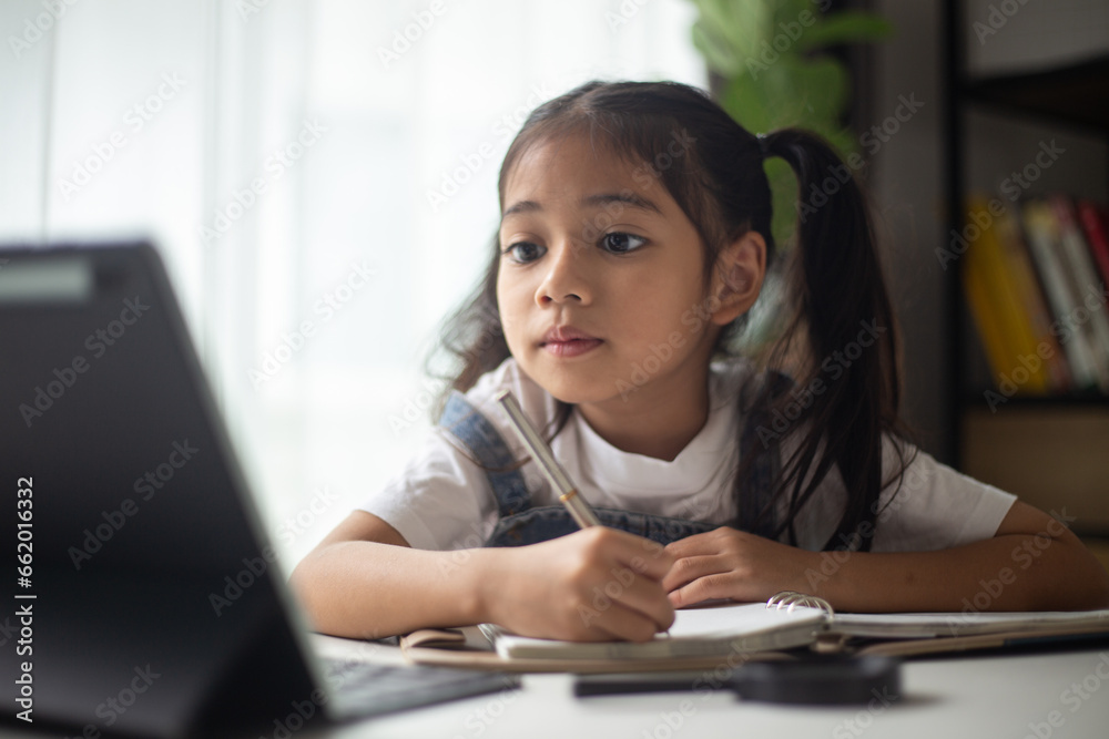 Young Asian Cute girl studying with laptop at home. Online learning concept. Young Asian Cute girl studying with laptop at home. Online learning concept.